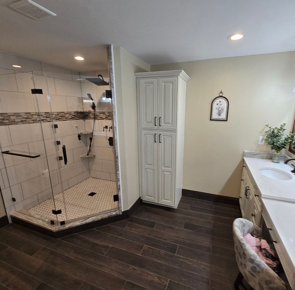 A bathroom with a walk in shower and a sink