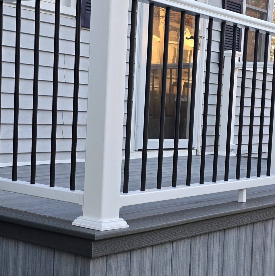 A porch with a white railing and black bars