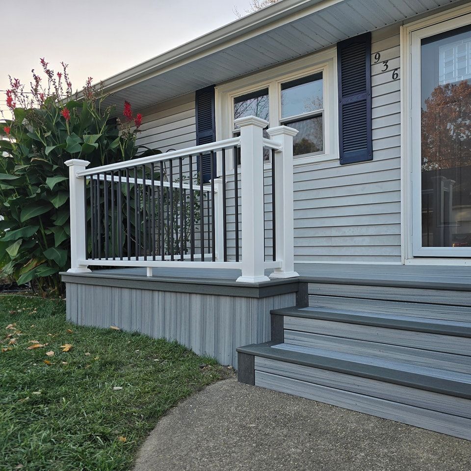 A white house with black shutters and a white railing