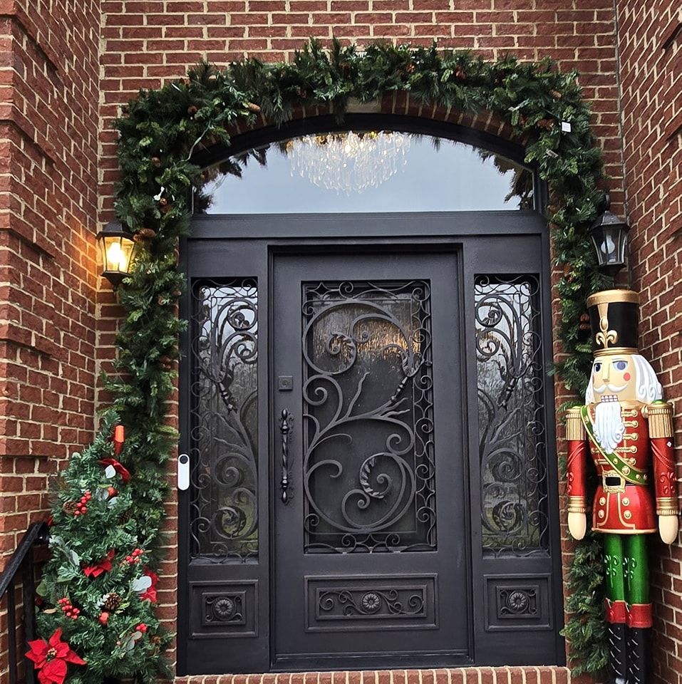 A black door with a nutcracker in front of it