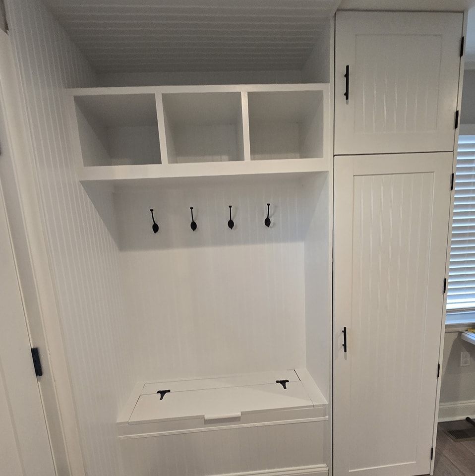 There is a bench in the middle of the room with hooks on the wall.