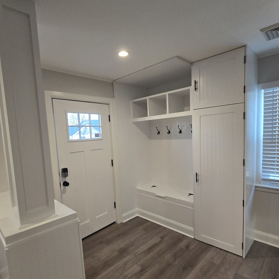A mud room with a bench and a window