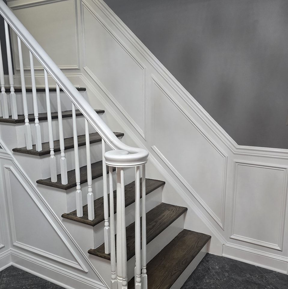 A white staircase with wooden steps and a white railing