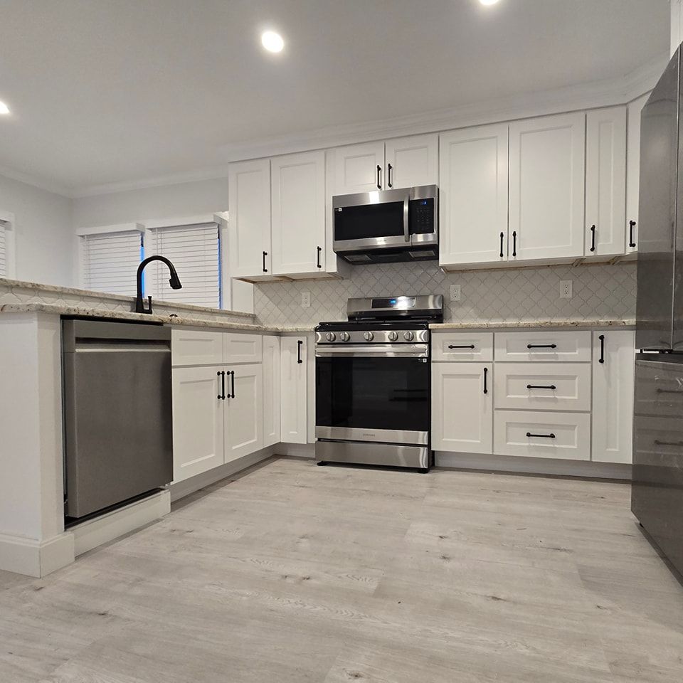 A kitchen with white cabinets and stainless steel appliances