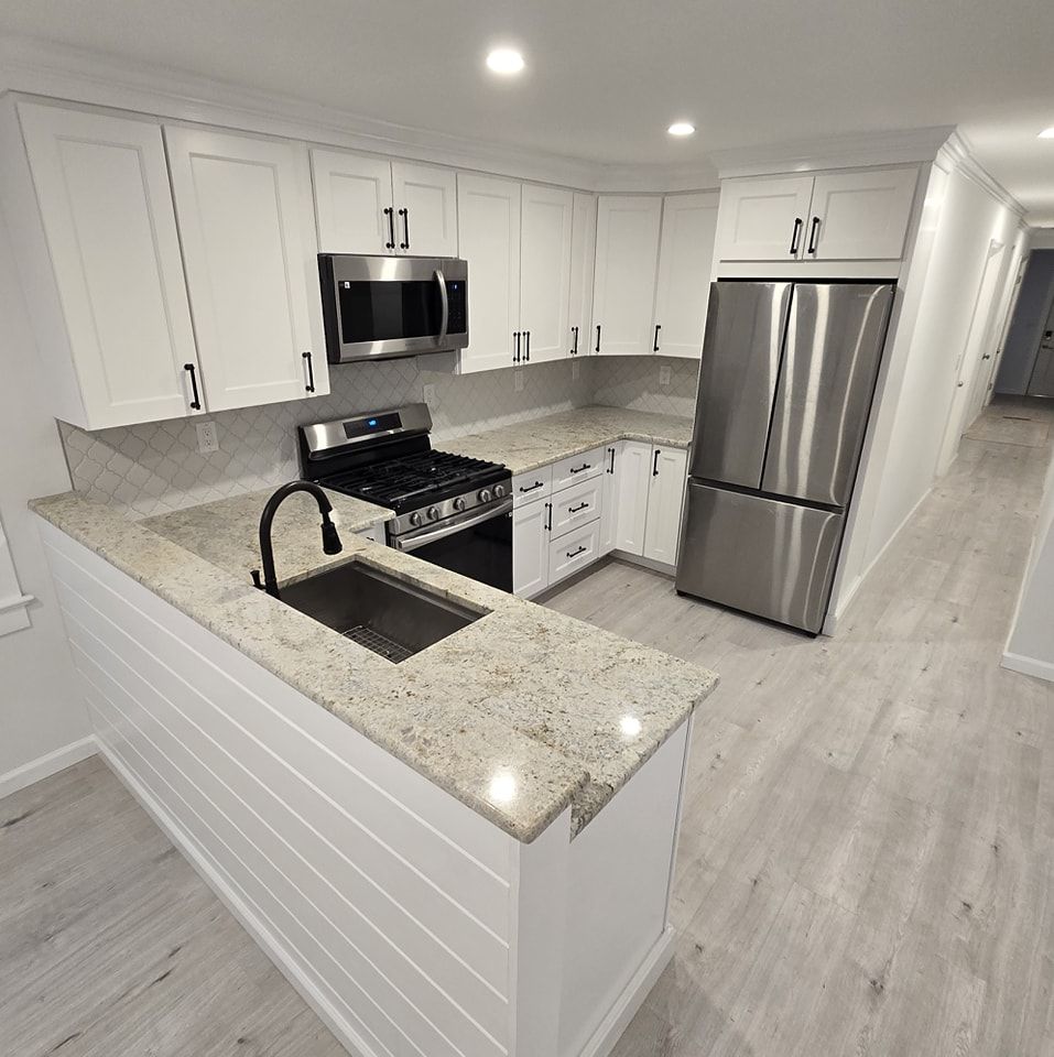 A kitchen with white cabinets and stainless steel appliances