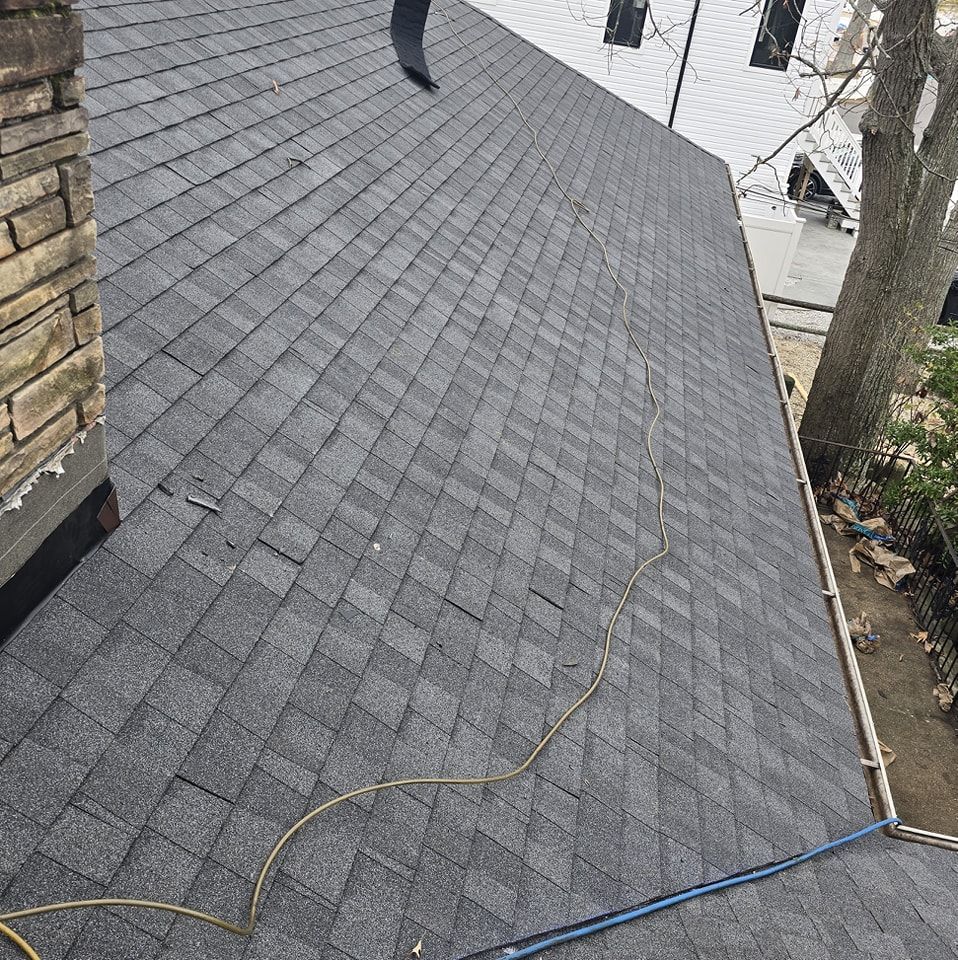 A close up of a roof with shingles and a chimney.