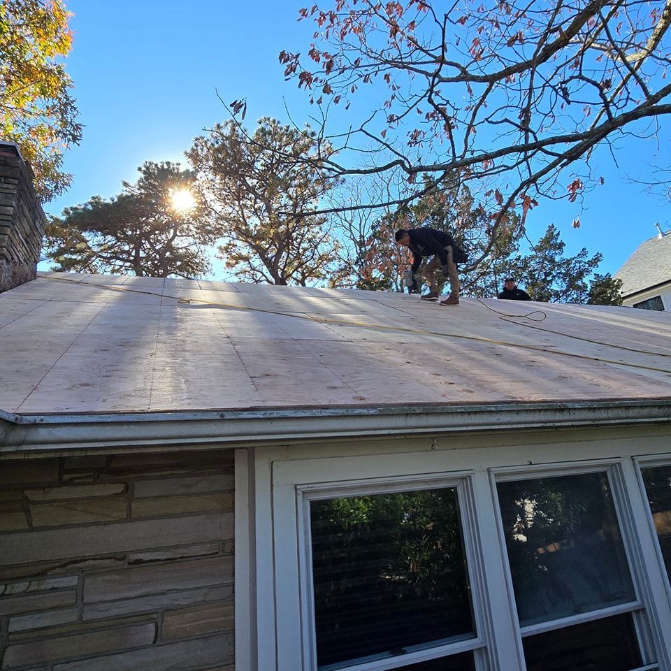 A man is working on the roof of a house.