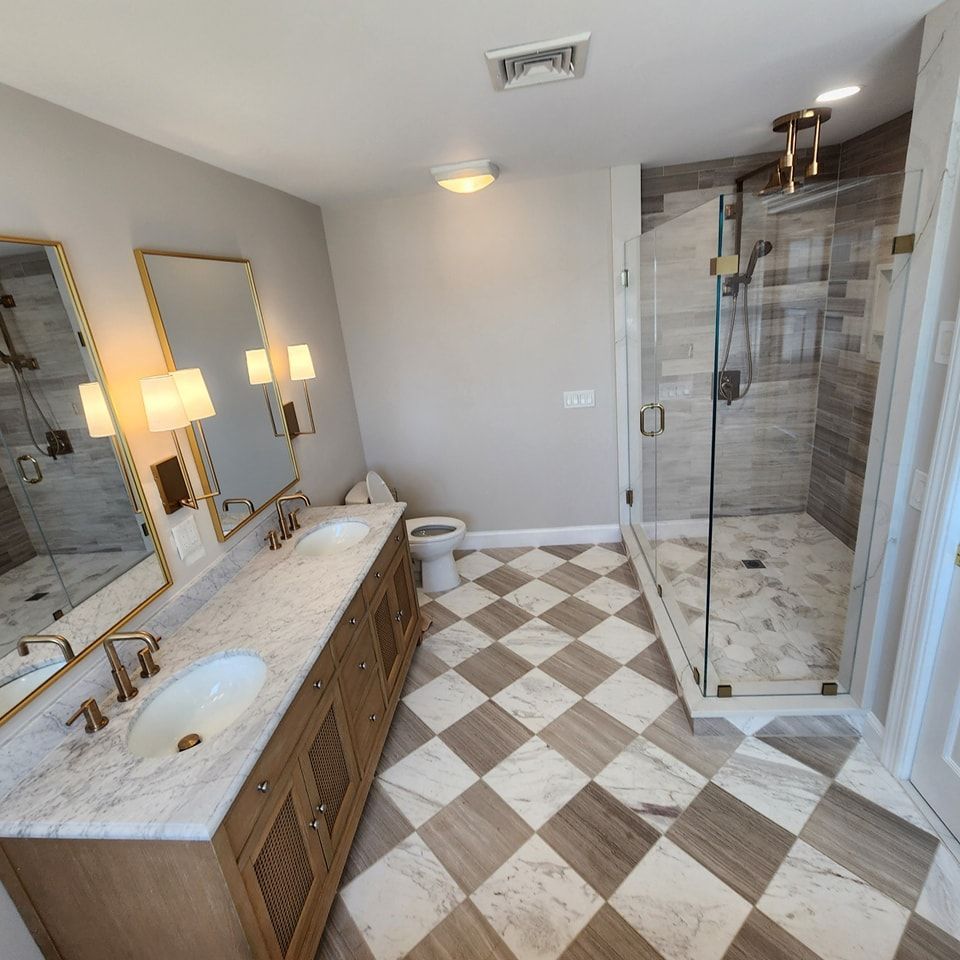 A bathroom with two sinks and a walk in shower