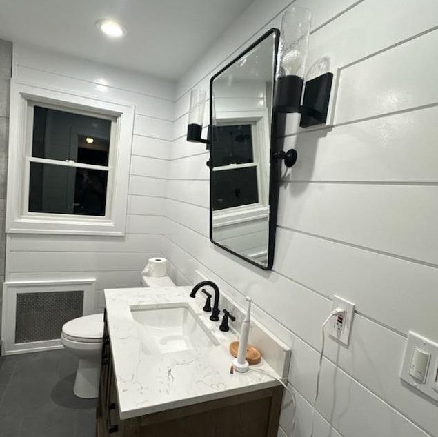 A bathroom with a sink , toilet and mirror