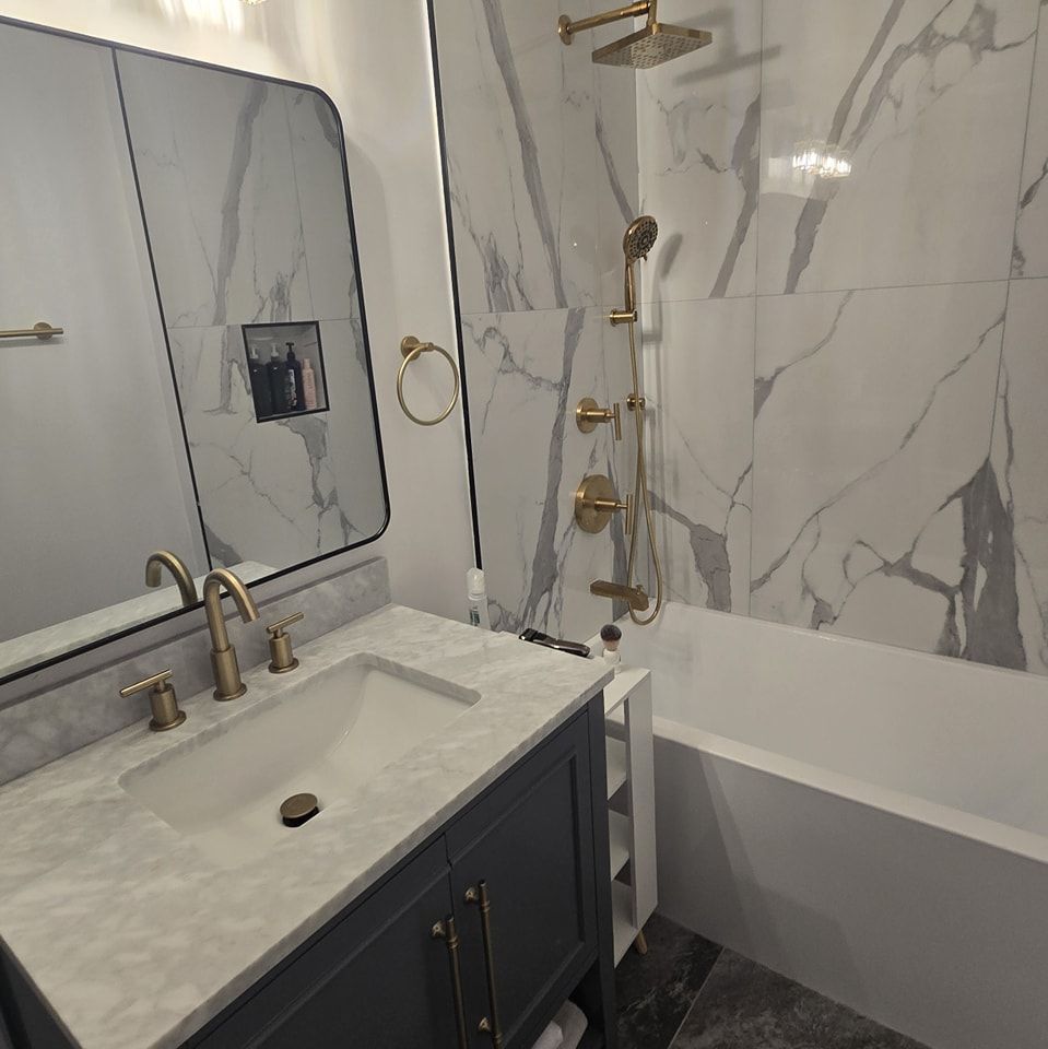 A bathroom with a sink , tub , shower and mirror