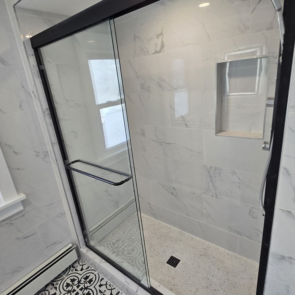 A bathroom with a sliding glass shower door