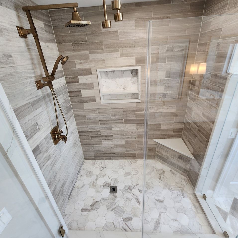 A bathroom with a walk in shower with a glass door