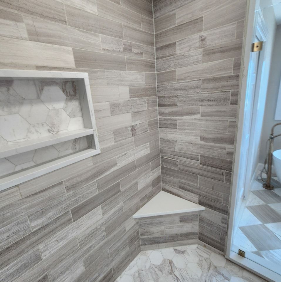 A bathroom with a walk in shower and a sink.