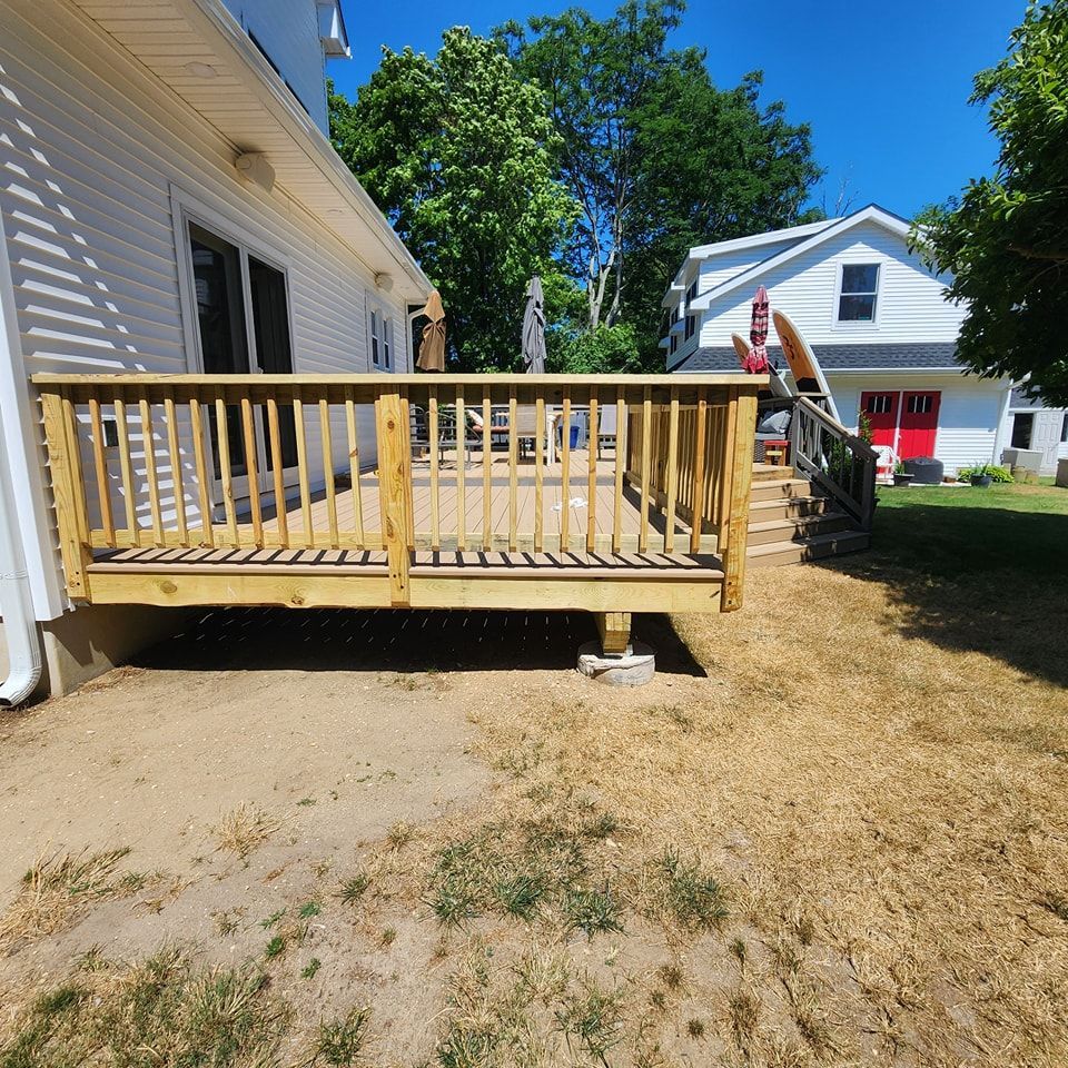 A wooden deck is in front of a white house