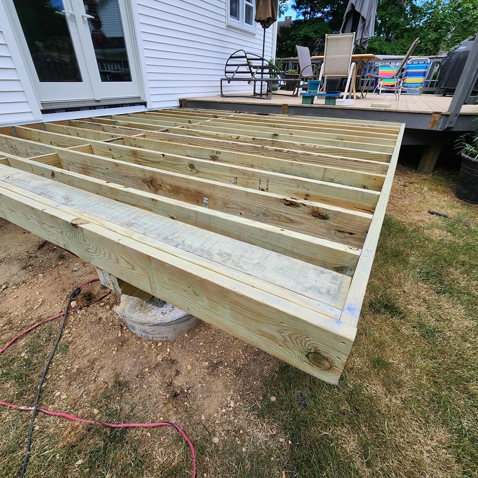 A wooden deck is being built in front of a house.