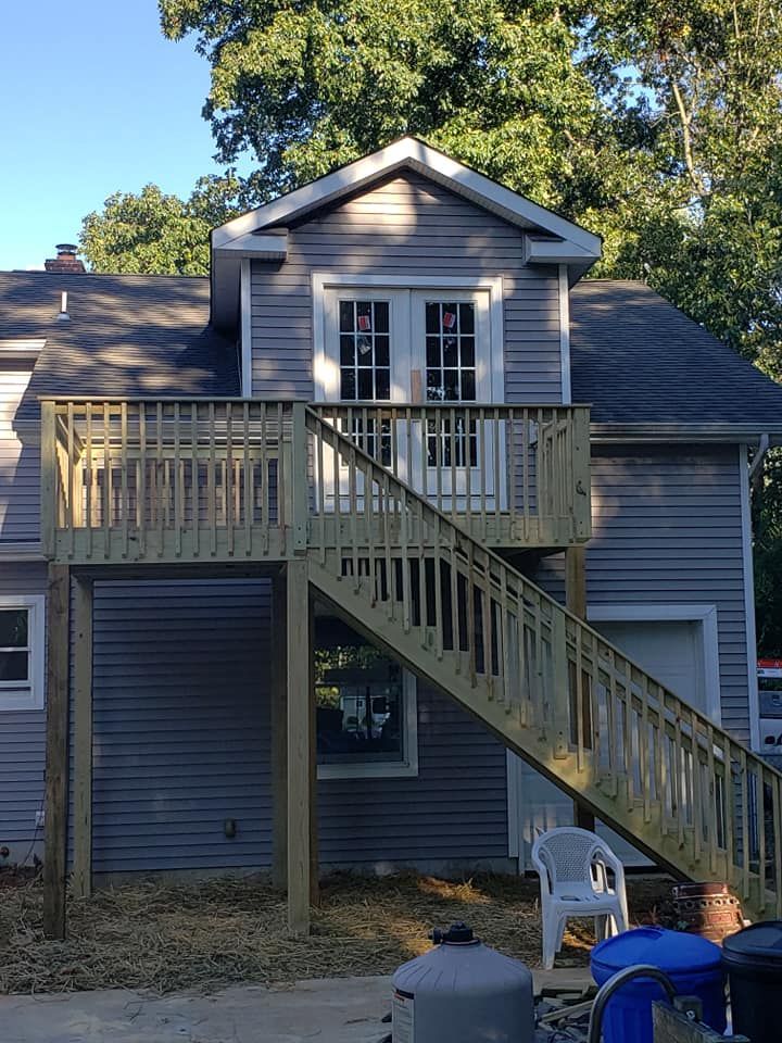 A house with a wooden deck and stairs leading up to it