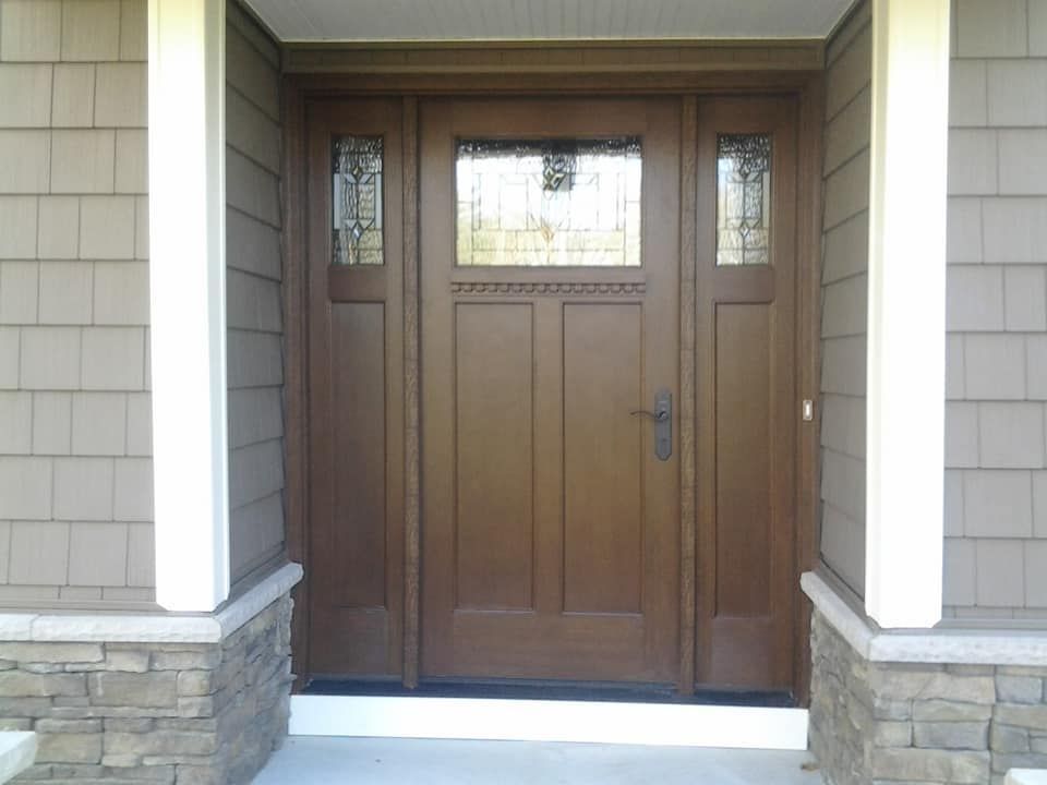 The front door of a house has a stained glass window