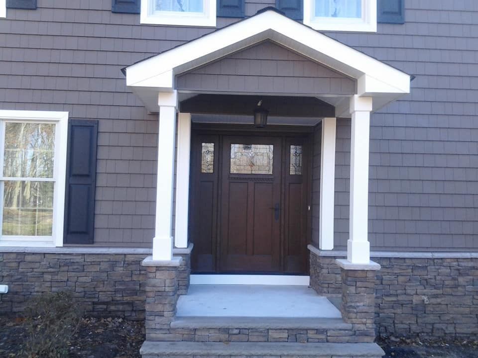A house with a porch and a brown door