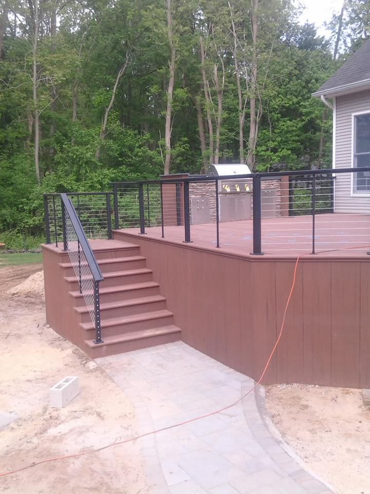 A wooden deck with stairs and a grill on it