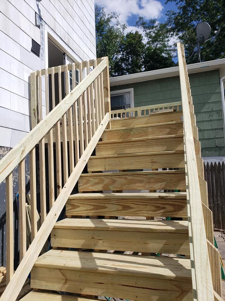 A set of wooden stairs leading up to a house.