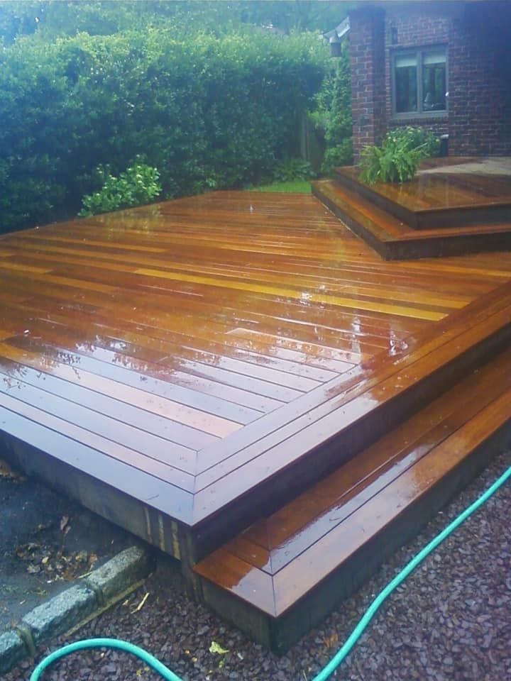 A wooden deck with stairs and a green hose