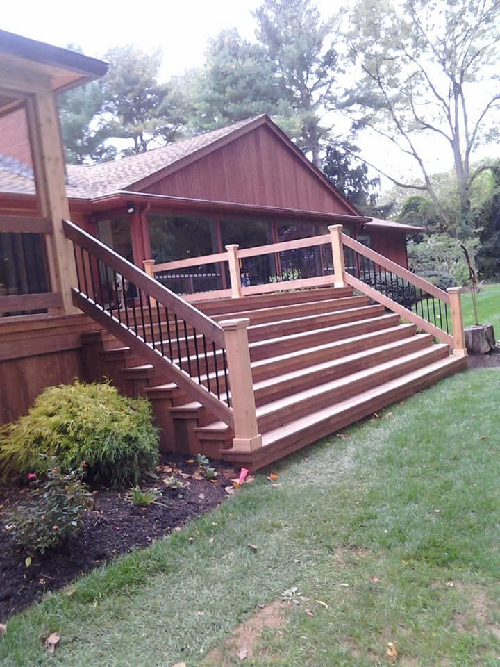 A wooden deck with stairs leading up to a house