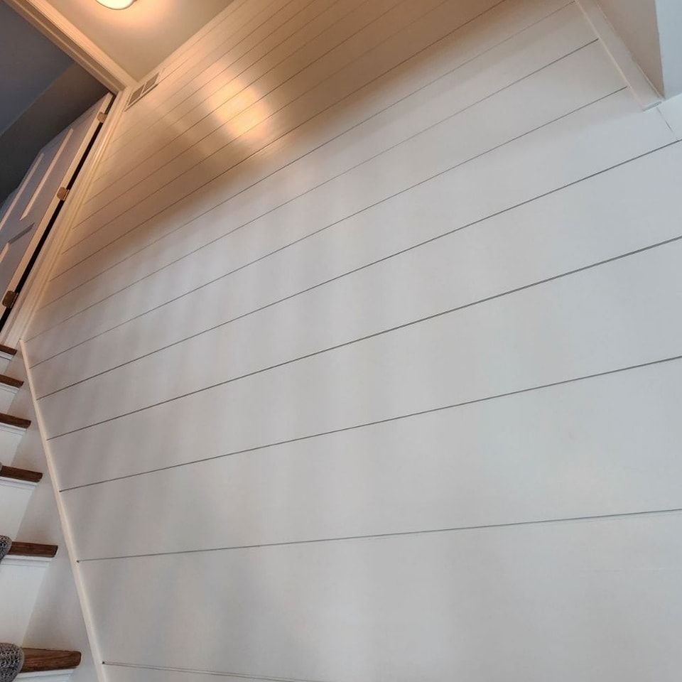 A white wall with wooden stairs leading up to it