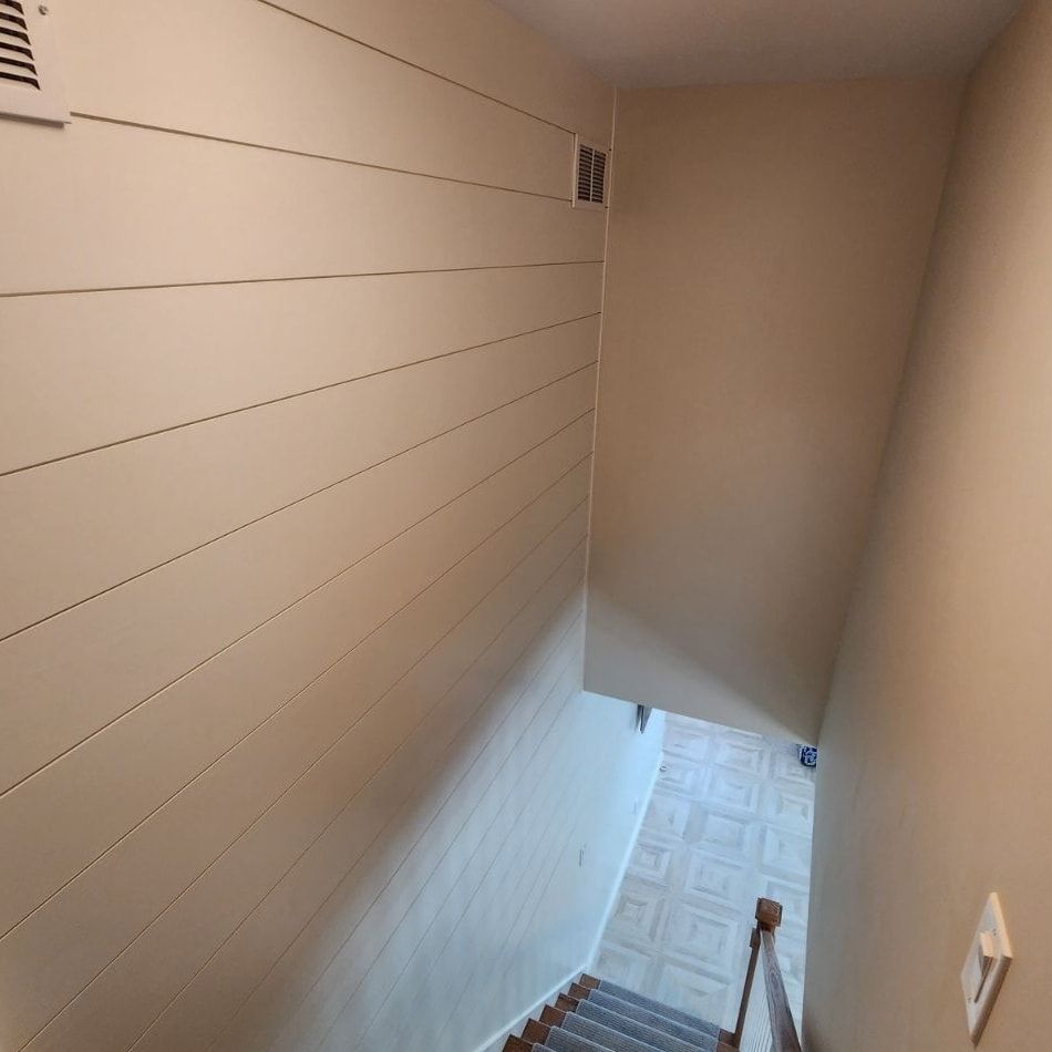 A staircase leading up to a basement with white walls and wooden steps.