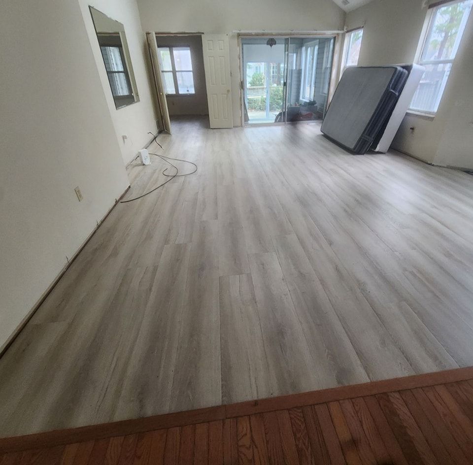 A mattress is sitting on a wooden floor in a living room.
