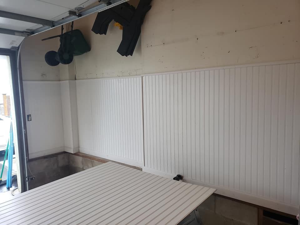A white wall with a table in the middle of it in a garage.