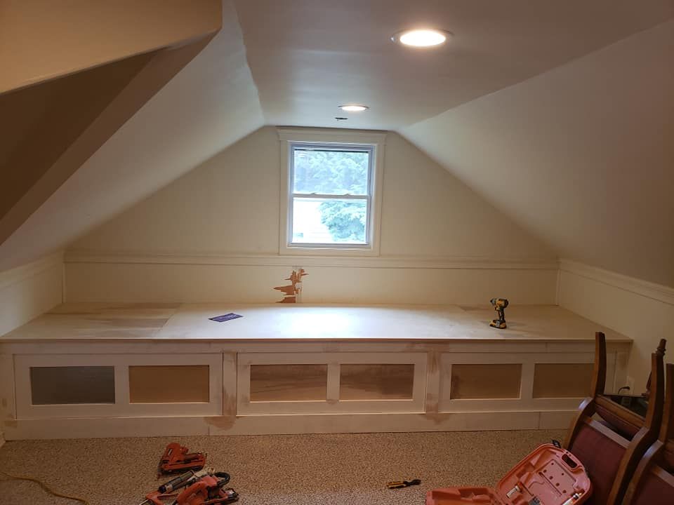 A room with a window and a shelf in the corner