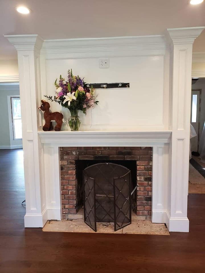 A fireplace with a vase of flowers on top of it