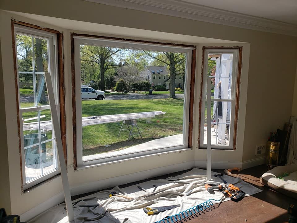 A living room with a large window and a table in front of it.
