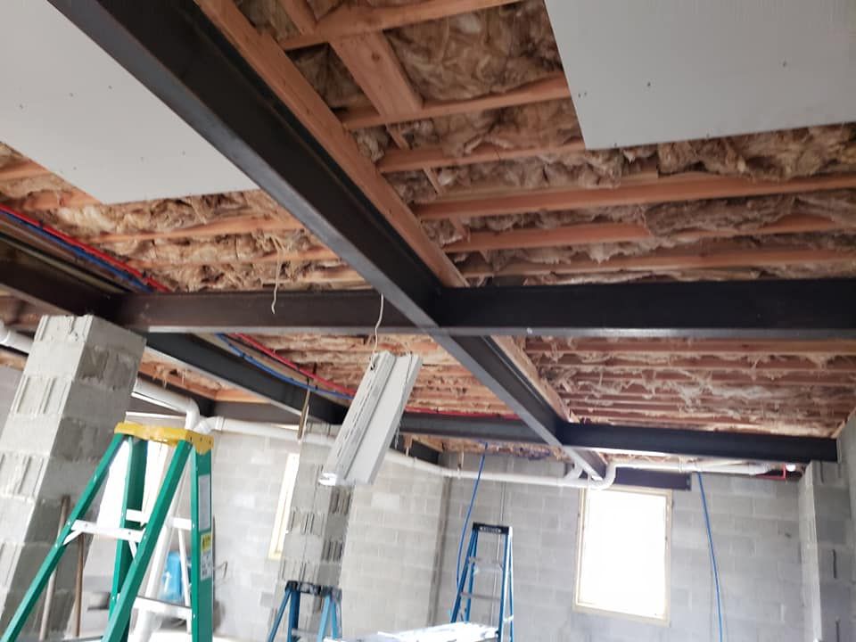 A ladder is in the middle of a room under construction