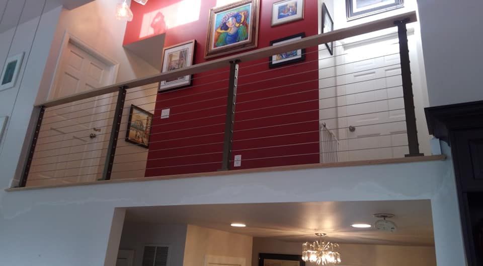 A living room with a balcony and a red wall