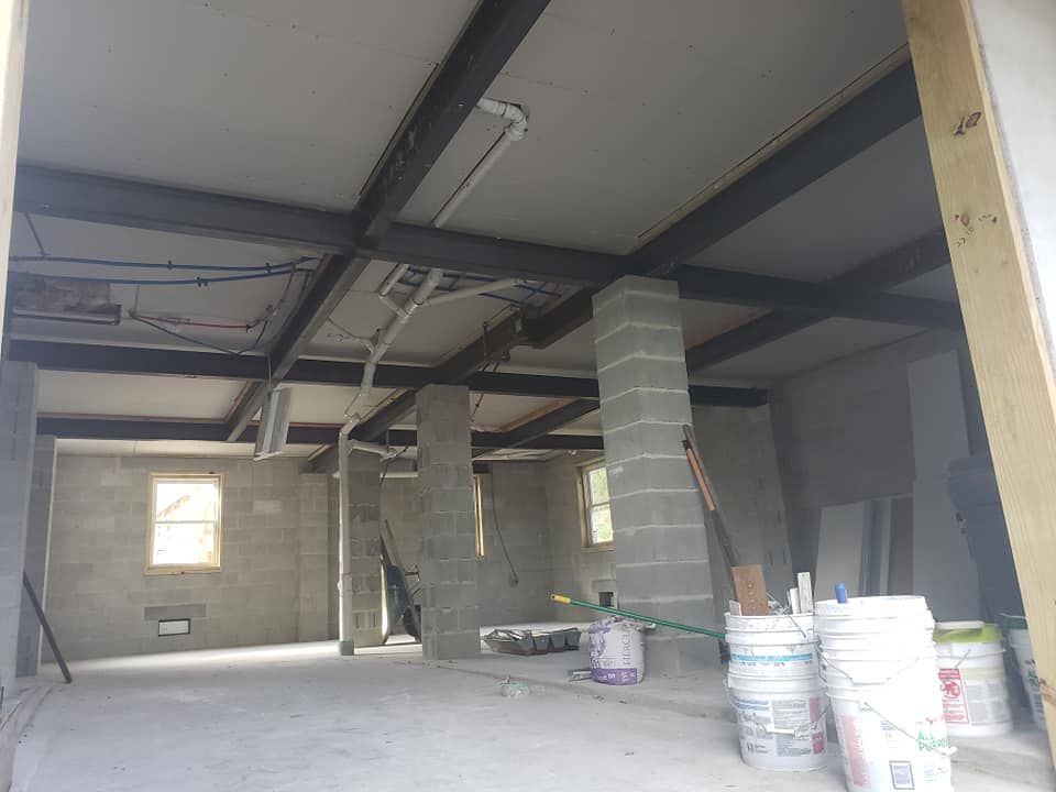 An empty room with buckets of paint on the floor