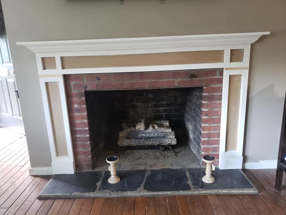 A brick fireplace with a white mantle in a living room
