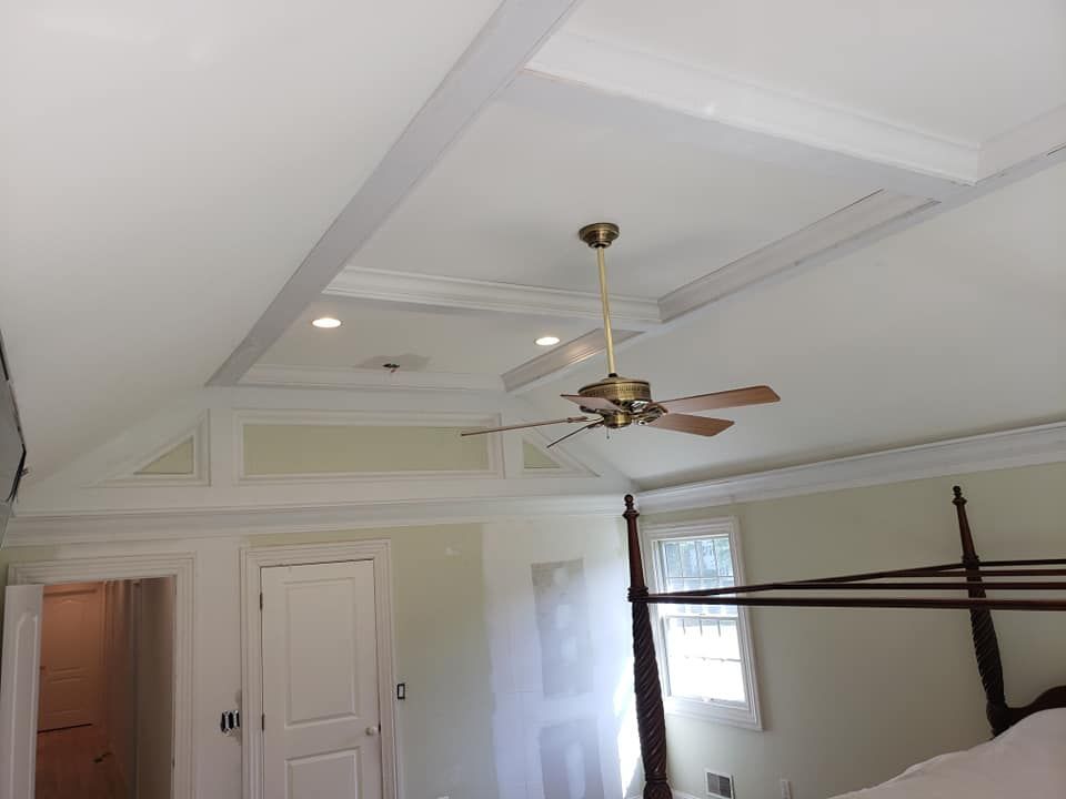 A bedroom with a canopy bed and a ceiling fan