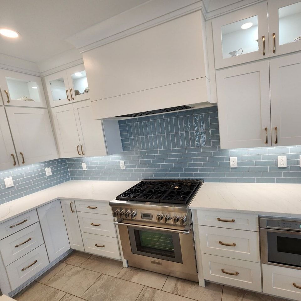 A kitchen with white cabinets and a stove top oven
