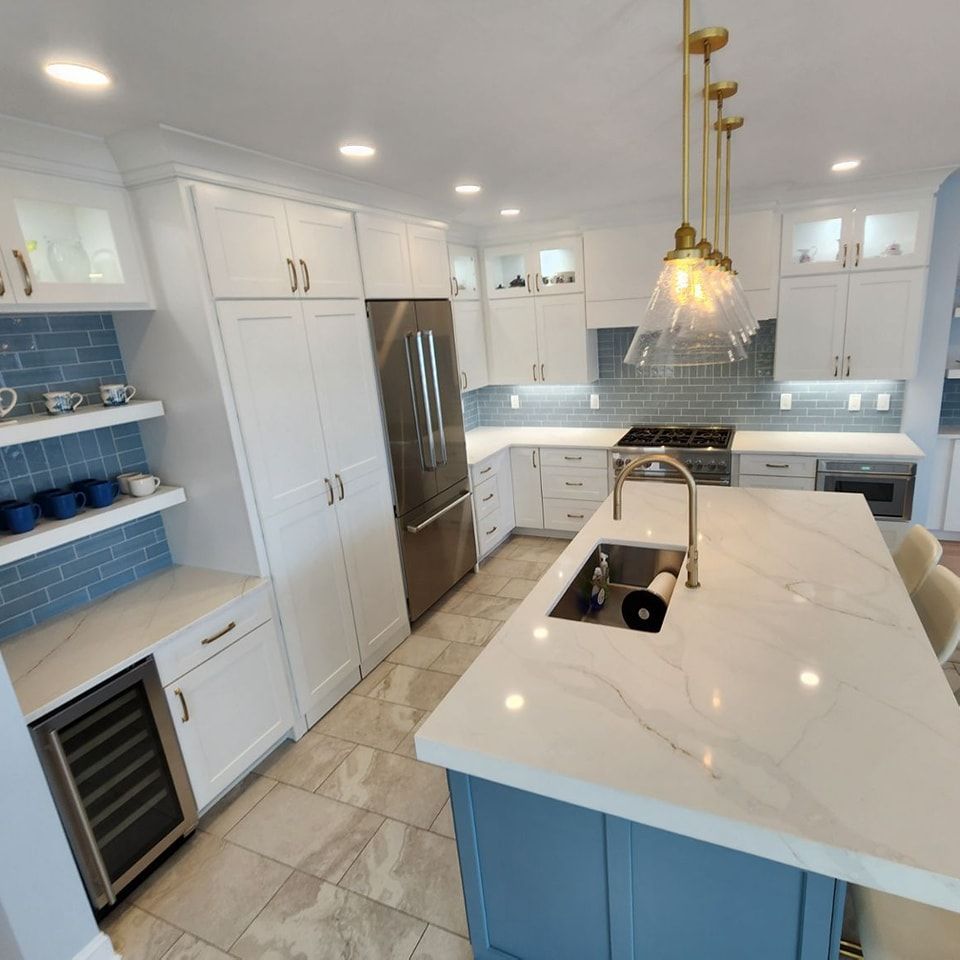 A kitchen with white cabinets and a blue island