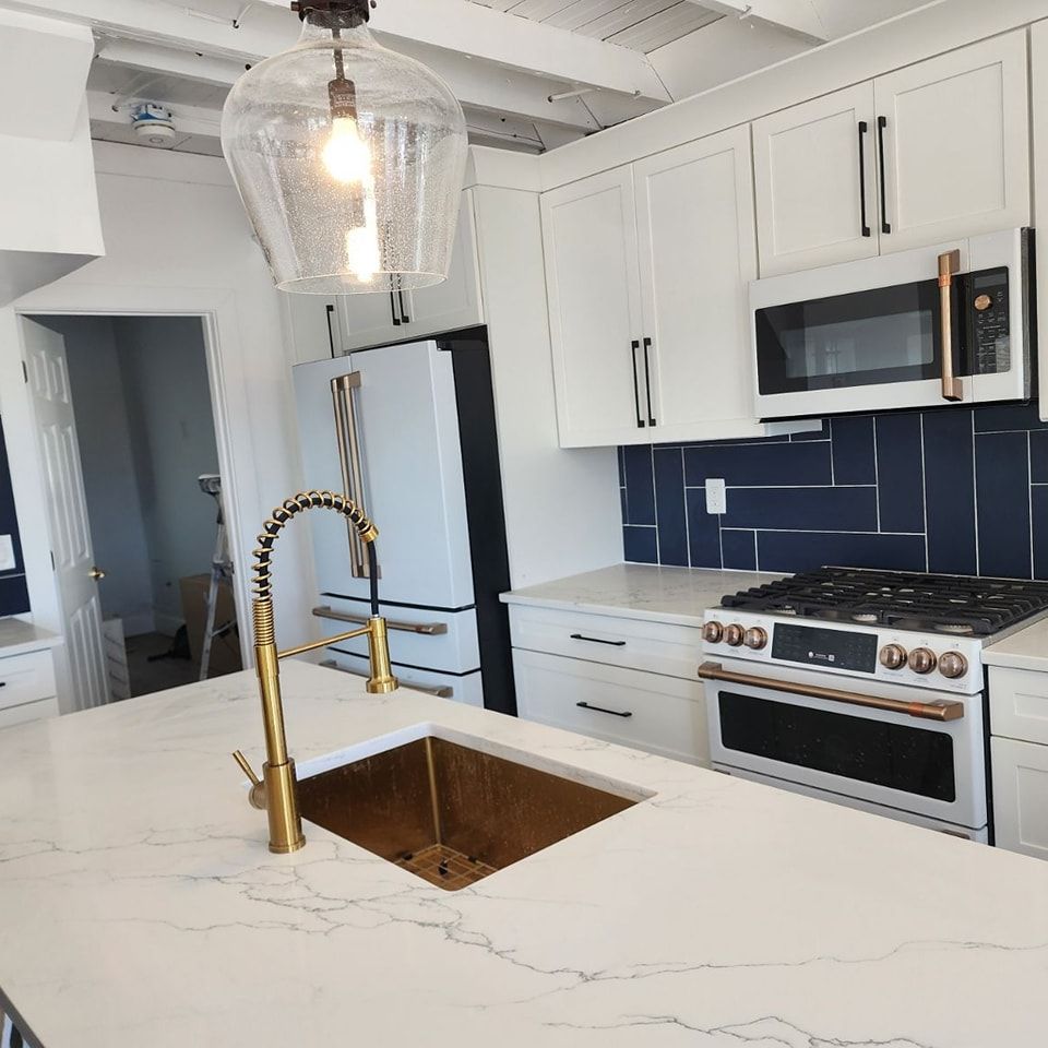 A kitchen with white cabinets and a stove and sink