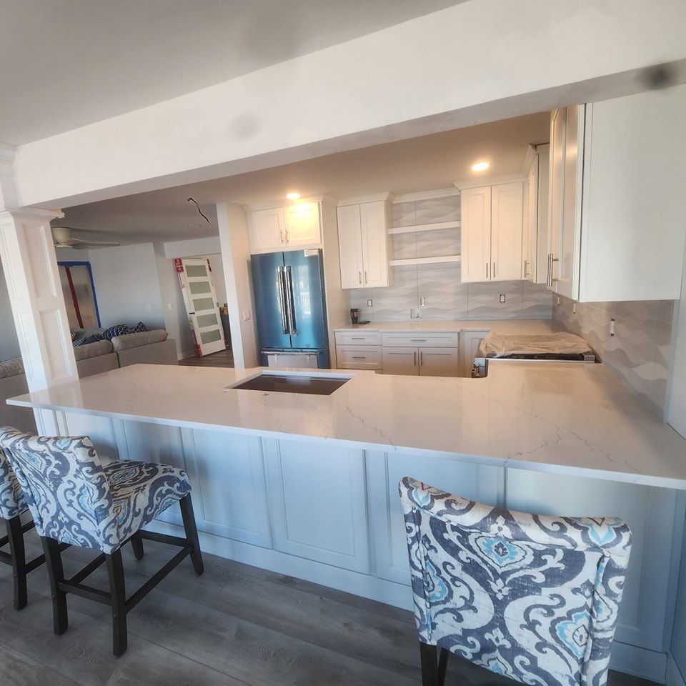 A kitchen with white cabinets and a blue refrigerator