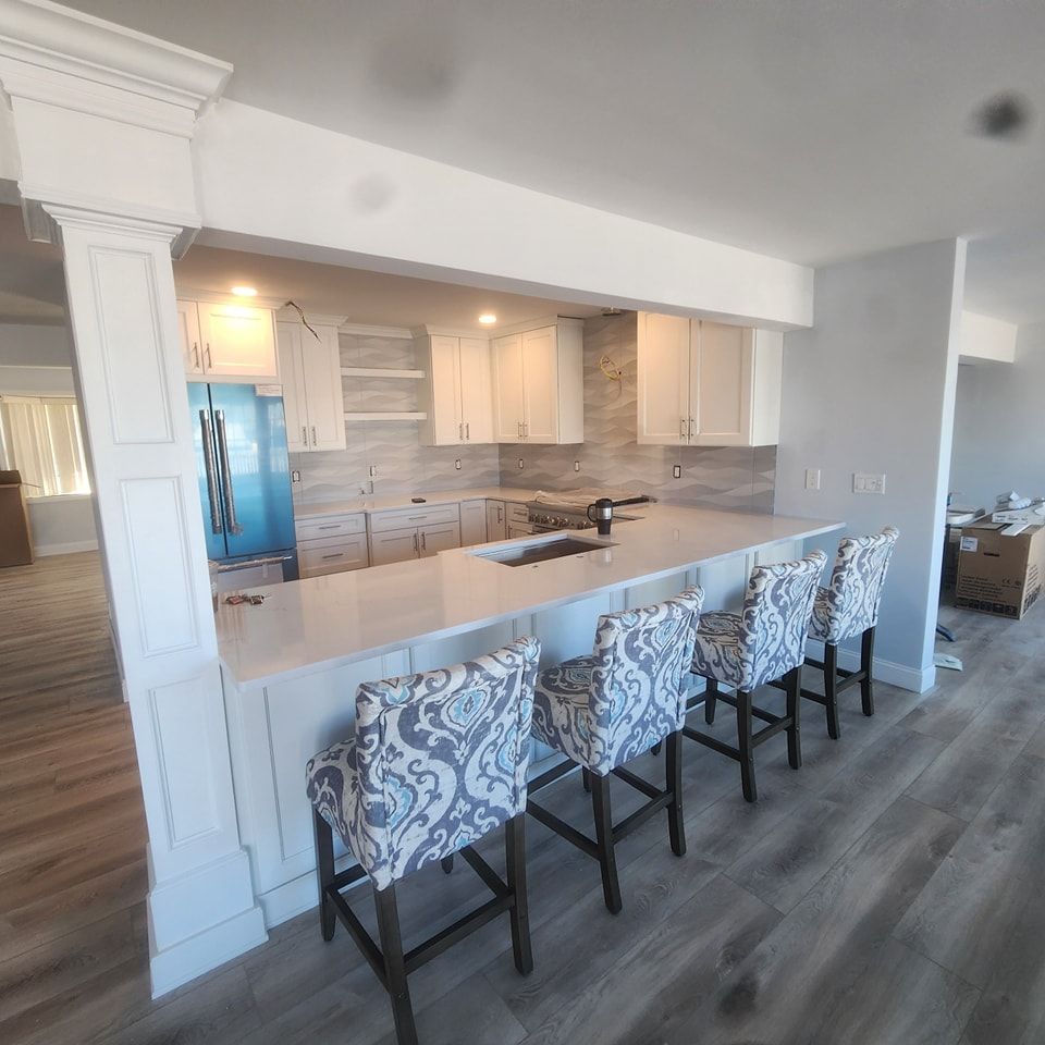 A kitchen with a bar and chairs in it