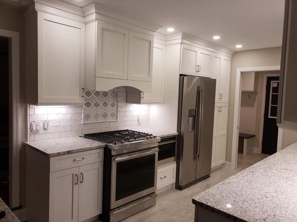 A kitchen with white cabinets and stainless steel appliances.