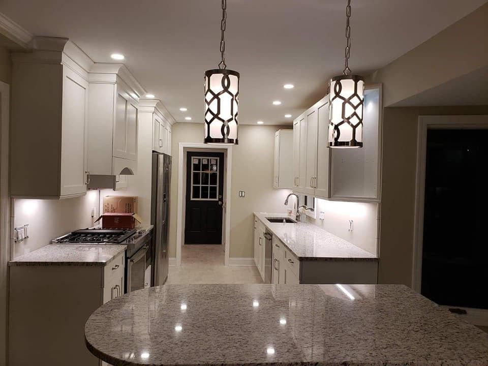 A kitchen with white cabinets and granite counter tops