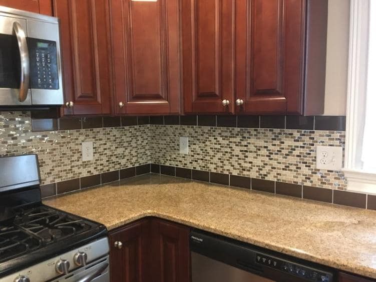 A kitchen with stainless steel appliances , granite counter tops , and wooden cabinets.