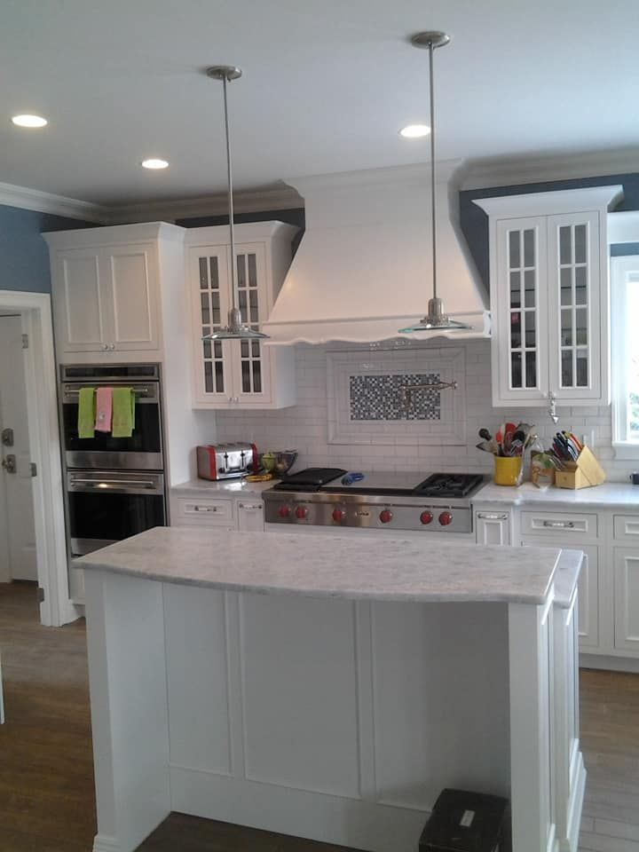 A kitchen with white cabinets and a stove top oven