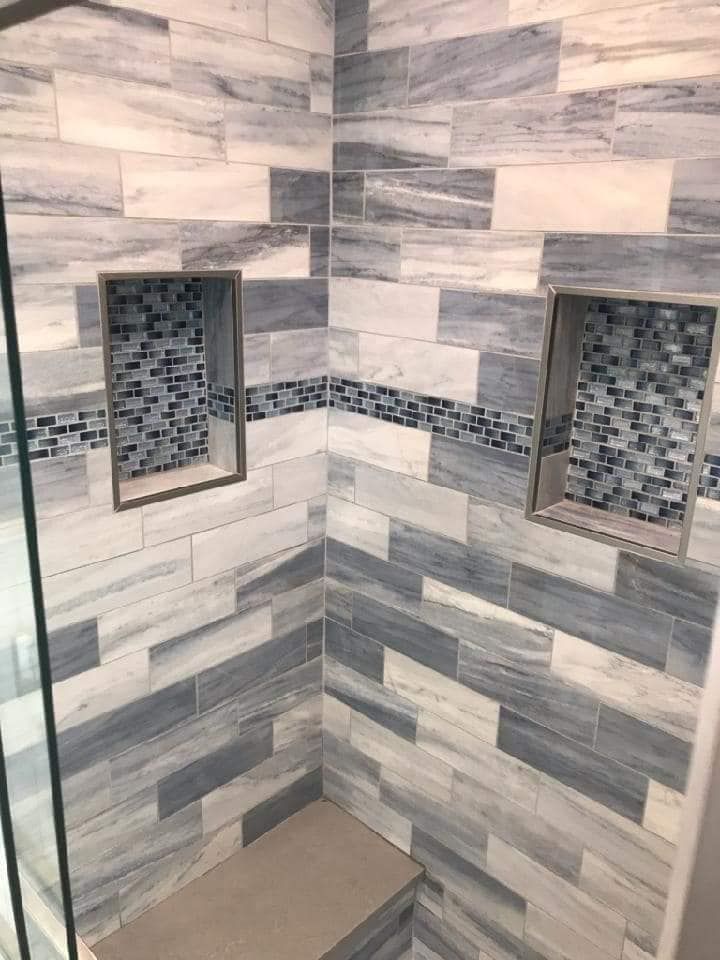 A bathroom with blue and white tiles and a glass shower door.