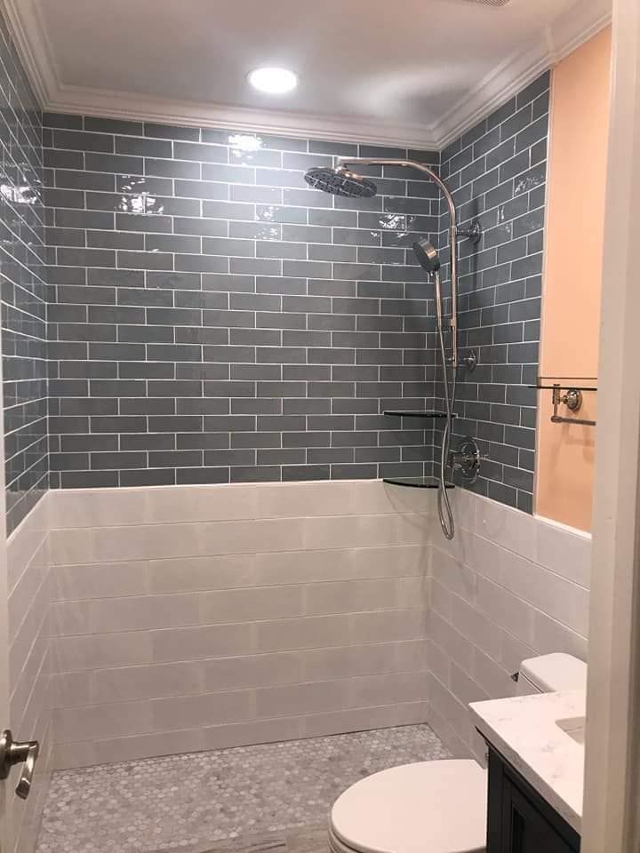 A bathroom with a shower , toilet and sink.