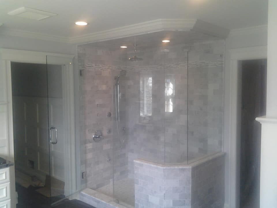 A bathroom with a tub and a shower with a glass door.
